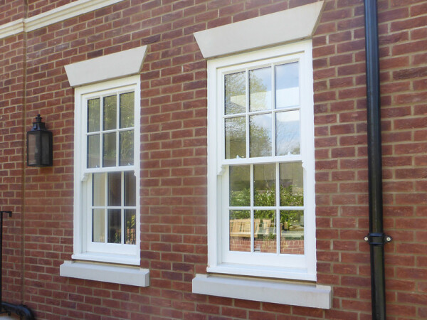 two bespoke timber sash windows on a brick wall
