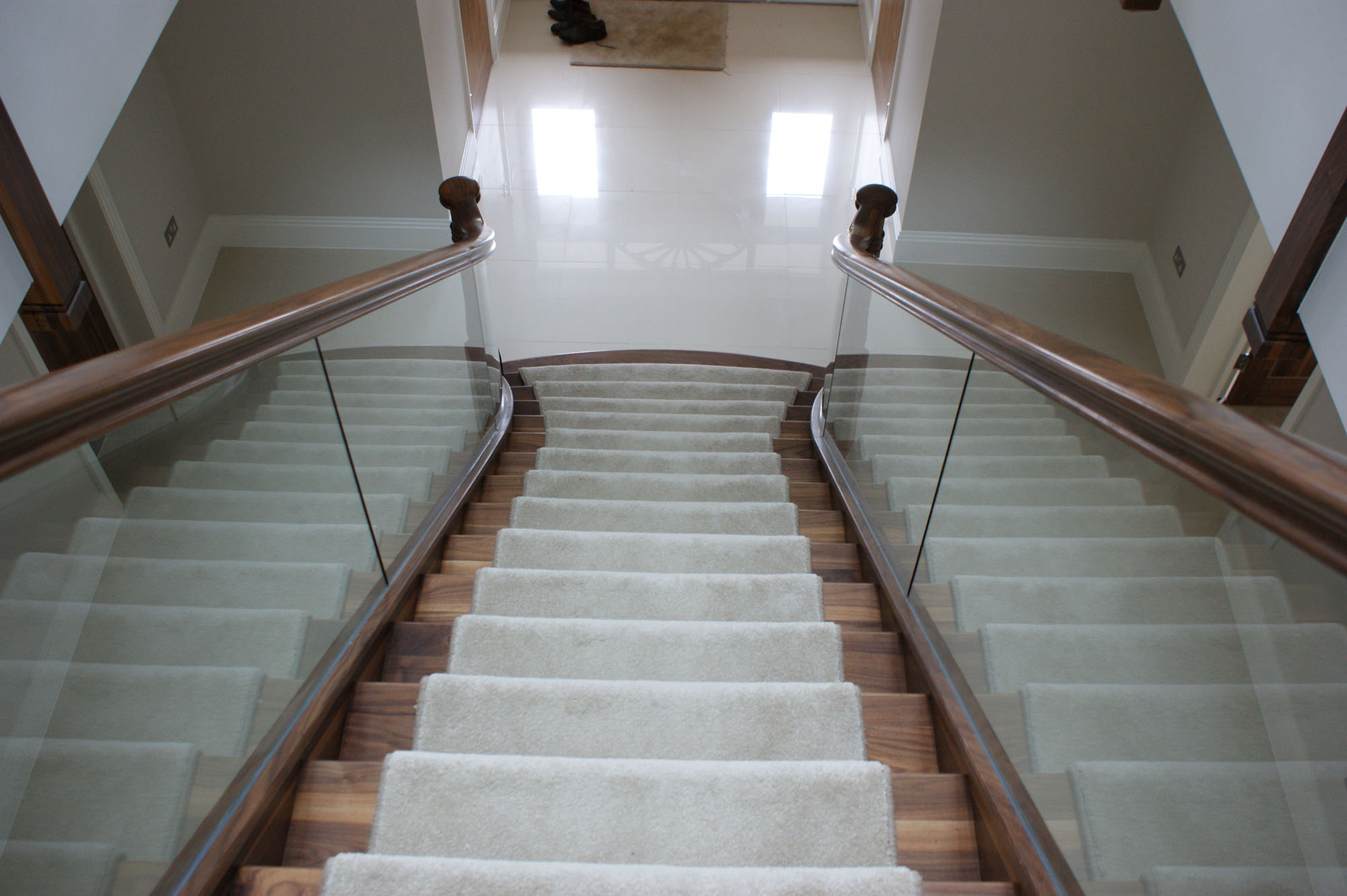 a view of looking down the staircase with glass balustrade